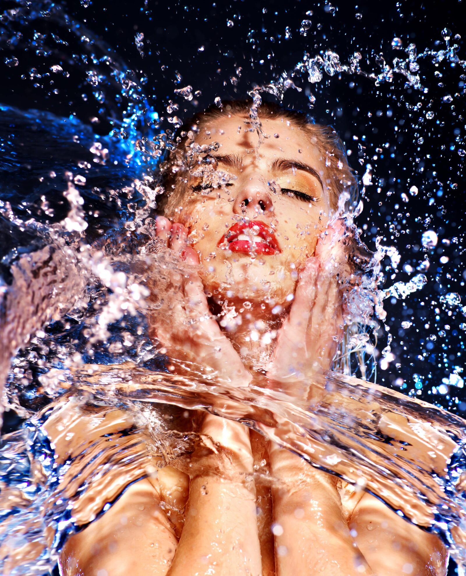beautiful woman splashing face with water
